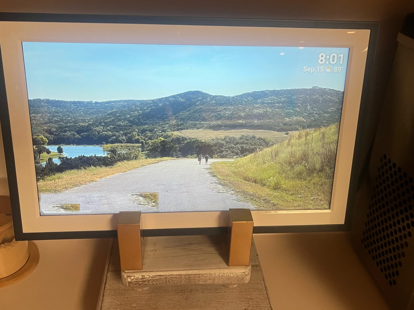 Sleek digital picture frame on a kitchen counter, hiding the outlet clutter behind it